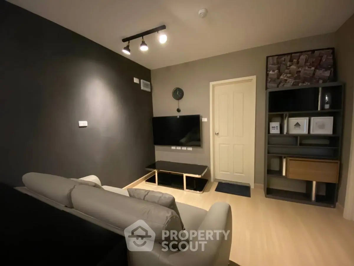 Modern living room with sleek furniture and wall-mounted TV in stylish apartment.