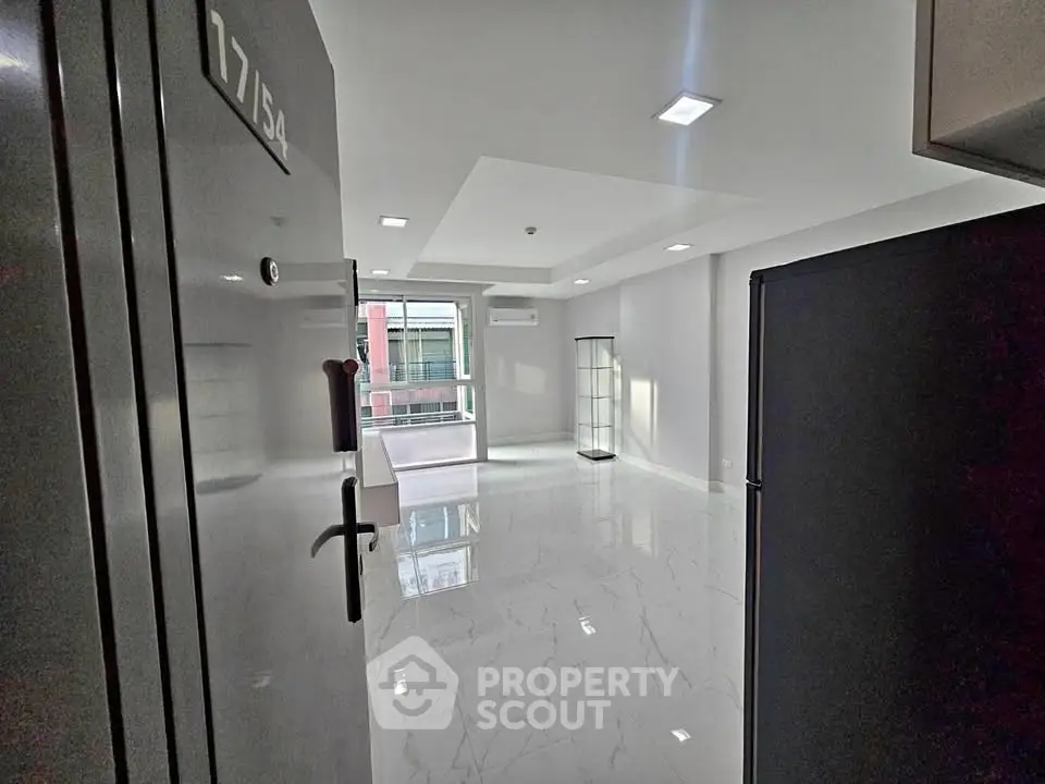 Modern apartment entrance with sleek flooring and natural light