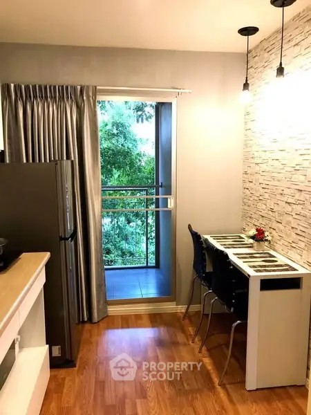 Modern kitchen with open layout and balcony view, featuring sleek design and natural light.