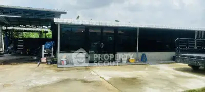 Spacious industrial-style property with large glass doors and ample parking space, ideal for commercial use.