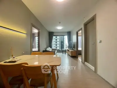 Modern apartment interior with open living and dining area, featuring stylish furniture and natural light.