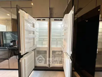 Spacious modern kitchen with open double-door refrigerator showcasing ample storage.