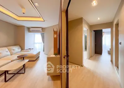 Spacious modern living room with elegant lighting and cozy seating in a stylish apartment.