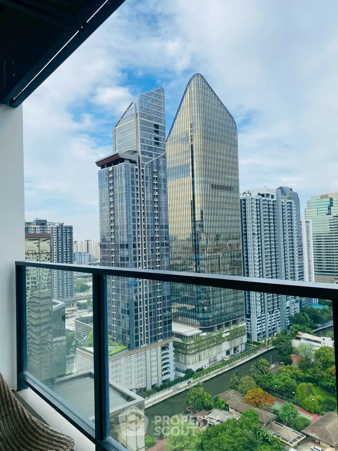 Stunning cityscape view from a modern high-rise balcony with sleek glass railing.