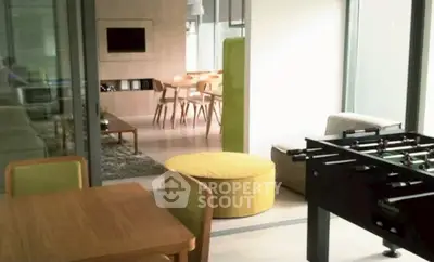 Modern living room with foosball table and stylish dining area, perfect for entertainment and relaxation.