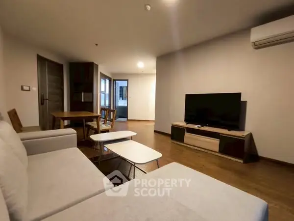 Spacious living room with modern furniture and large TV, perfect for relaxation.
