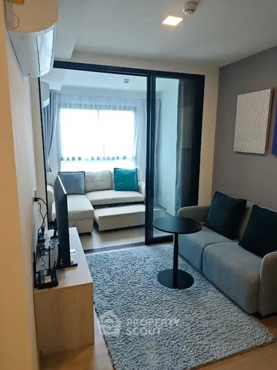 Modern living room with cozy seating and natural light, perfect for relaxation and entertainment.