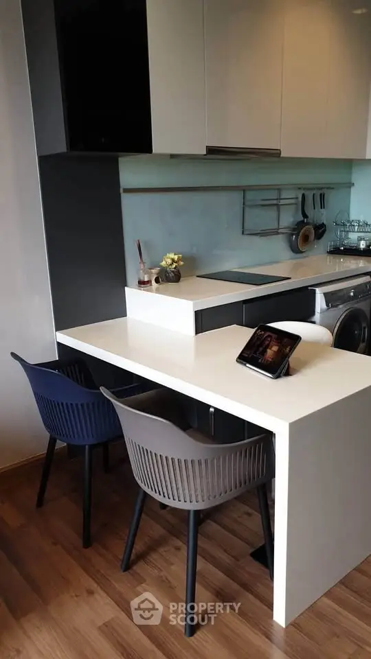 Modern kitchen with sleek design, featuring a compact dining area and integrated appliances.