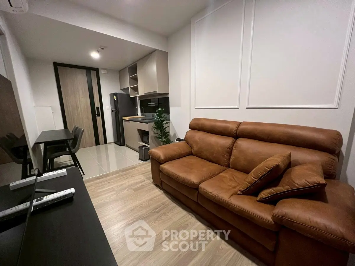 Modern living room with brown leather sofa and open kitchen layout