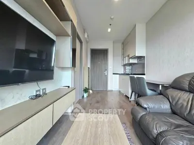 Modern living room with sleek furniture and open kitchen layout in a stylish apartment.