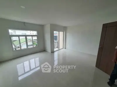 Spacious empty room with large windows and balcony access, perfect for customization.