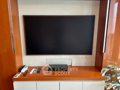 Modern living room with sleek TV setup and wooden cabinetry, perfect for entertainment enthusiasts.