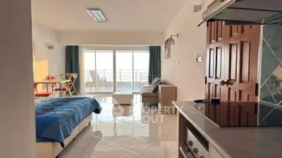 Spacious open-plan studio with modern kitchen and balcony view, perfect for urban living.
