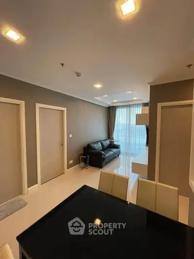 Modern living room with sleek furniture and large windows offering natural light.