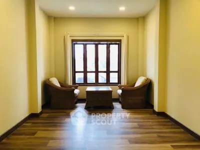 Cozy sitting area with wicker chairs and wooden flooring, perfect for relaxation.