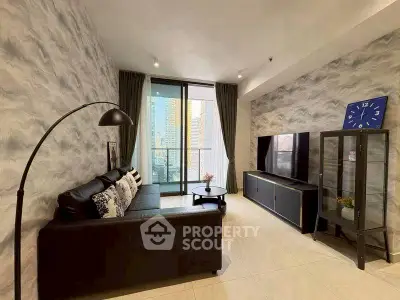 Modern living room with stylish decor and city view, featuring a sleek black sofa and large TV.