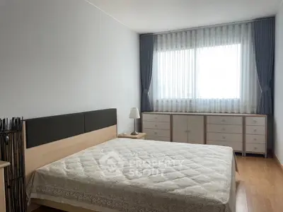 Spacious bedroom with natural light and modern furnishings