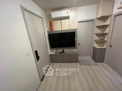 Modern living room with sleek design, featuring a wall-mounted TV and air conditioning unit.