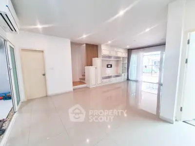 Spacious modern living room with glossy tile flooring and built-in storage