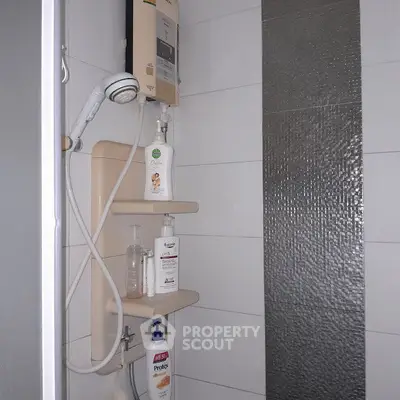 Compact bathroom shower area with modern fixtures and storage shelves.