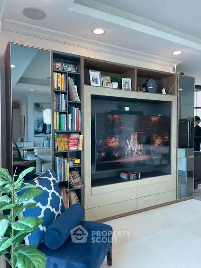 Luxurious living room with built-in entertainment center and cozy fireplace ambiance.