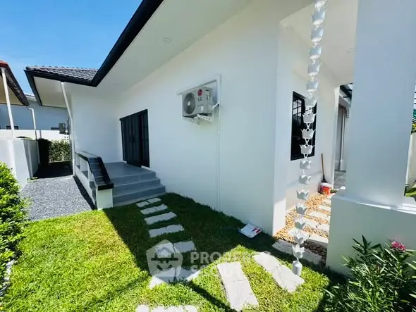 Charming modern home exterior with lush green lawn and sleek design.