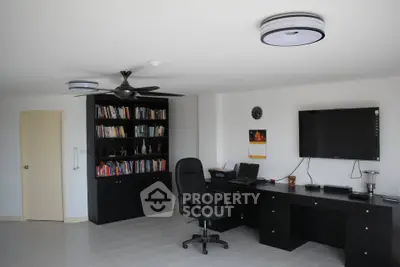 Spacious home office with modern desk and bookshelf, ideal for productivity.