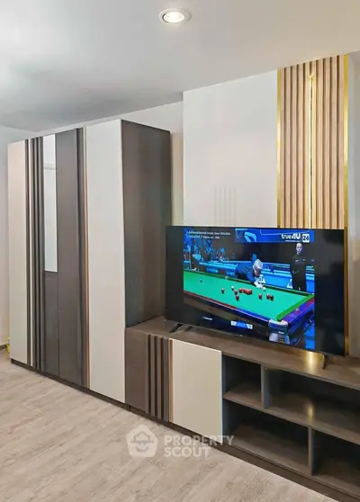 Modern living room with sleek entertainment unit and flat-screen TV, perfect for relaxation and entertainment.
