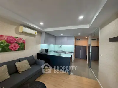 Modern open-layout living room and kitchen with stylish decor and cozy ambiance.