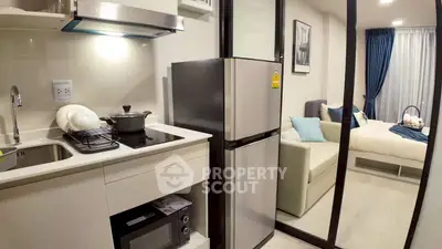 Modern compact kitchen with stainless steel appliances and cozy living area