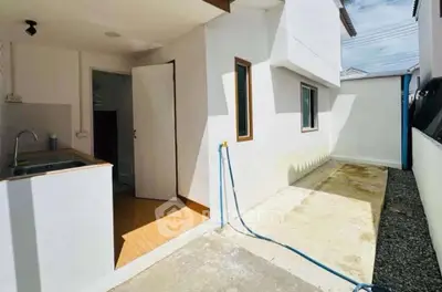 Spacious outdoor area with utility sink and hose, perfect for gardening or outdoor chores.