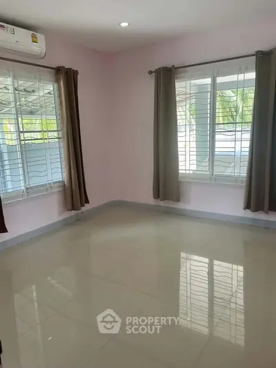 Spacious empty room with large windows and tiled floor, perfect for customization.