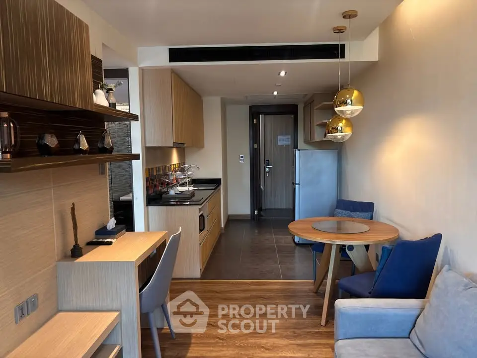 Modern open-plan living room with stylish kitchen and dining area, featuring elegant decor and cozy seating.