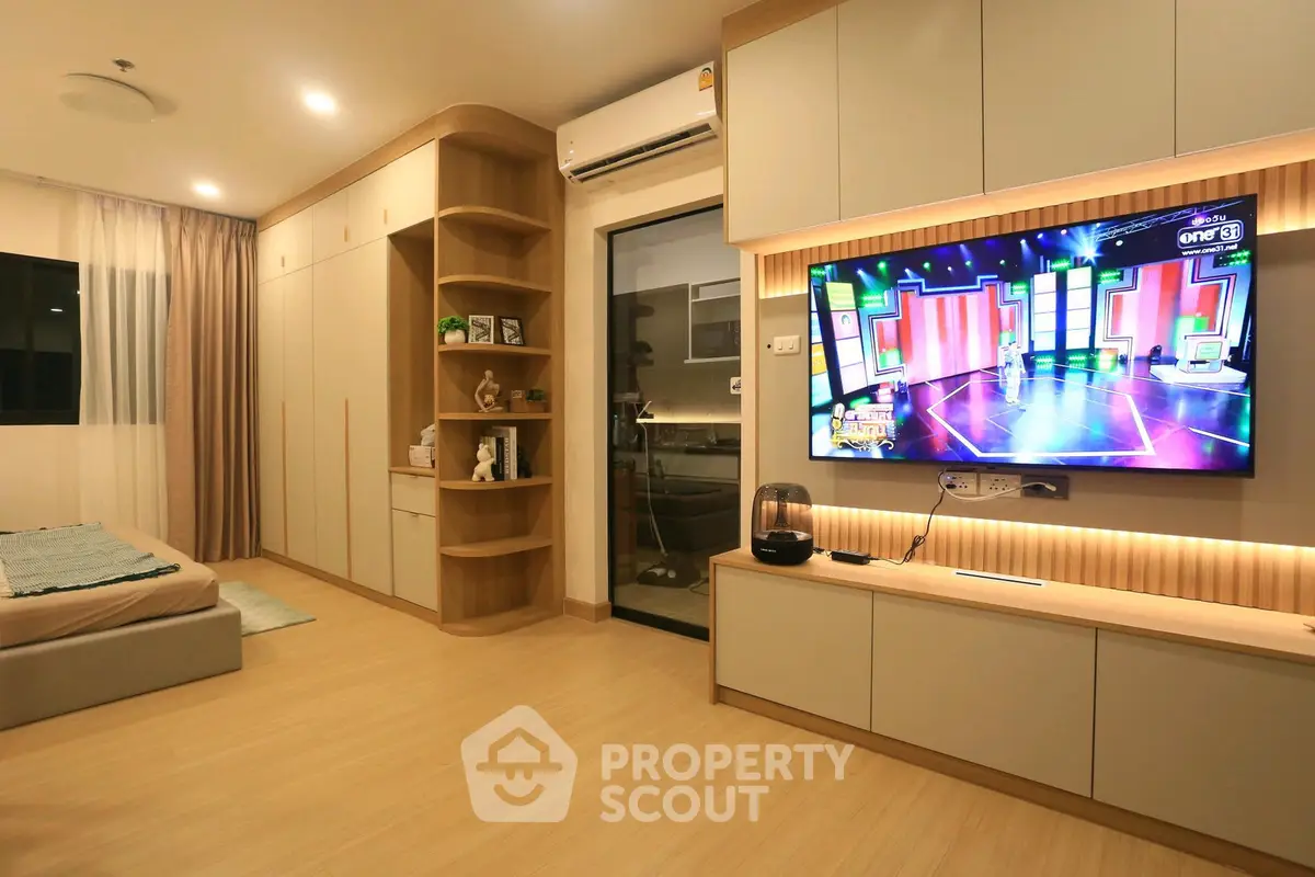 Modern bedroom with built-in storage and wall-mounted TV, featuring sleek design and warm lighting.