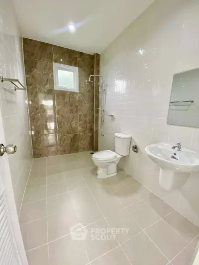 Spacious modern bathroom with elegant tile design and natural light.
