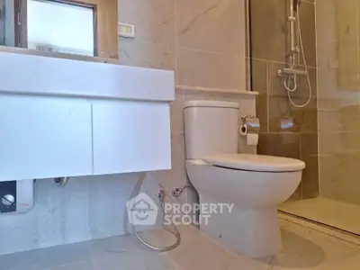 Modern bathroom with sleek fixtures and elegant tile design, featuring a shower and toilet.