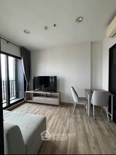 Modern living room with sleek furniture and balcony view in a stylish apartment.