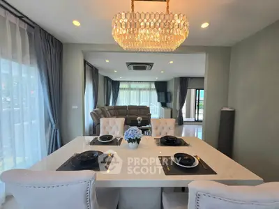 Luxurious dining area with elegant chandelier and spacious living room view