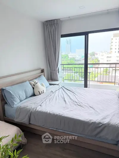 Bright bedroom with large window and balcony view in modern apartment