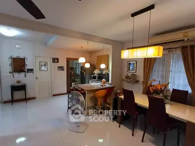 Spacious open-plan living and dining area with modern lighting and decor