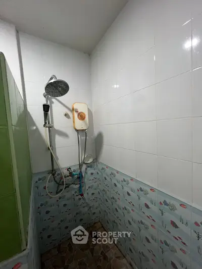 Cozy bathroom with tiled walls and modern shower setup, perfect for a refreshing start to your day.