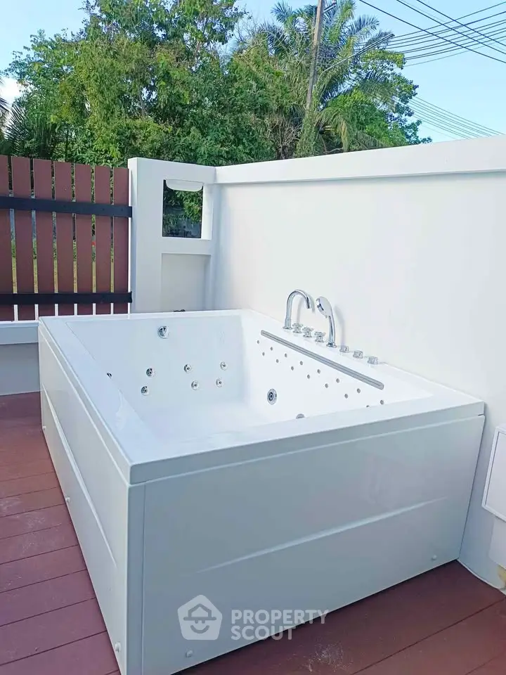 Luxurious outdoor jacuzzi tub on a private deck with lush greenery view.