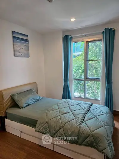 Cozy bedroom with large window and stylish decor, perfect for relaxation.