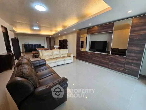 Spacious modern living room with elegant leather sofas and sleek entertainment unit.