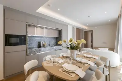 Elegant dining area with modern kitchen and cozy living space, featuring sleek cabinetry and stylish decor.