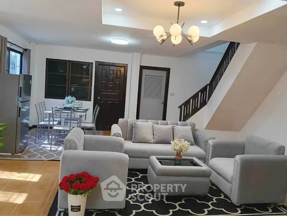 Spacious living room with modern furniture and dining area in a stylish home.