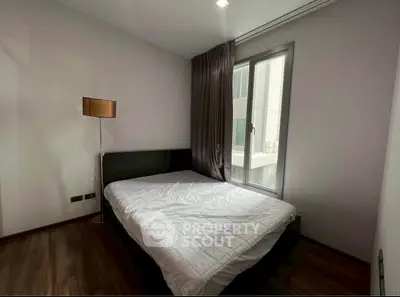 Cozy bedroom with large window and modern decor in a stylish apartment.