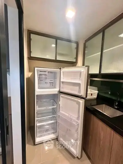 Modern kitchen with open fridge and sleek cabinetry
