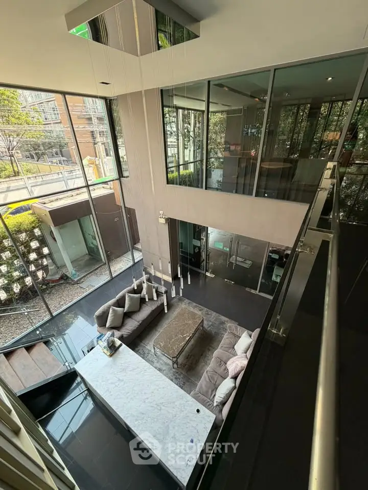 Luxurious modern living room with high ceilings and large windows offering stunning views.