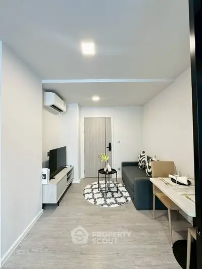 Modern living room with stylish decor, featuring a cozy sofa, flat-screen TV, and elegant dining area.